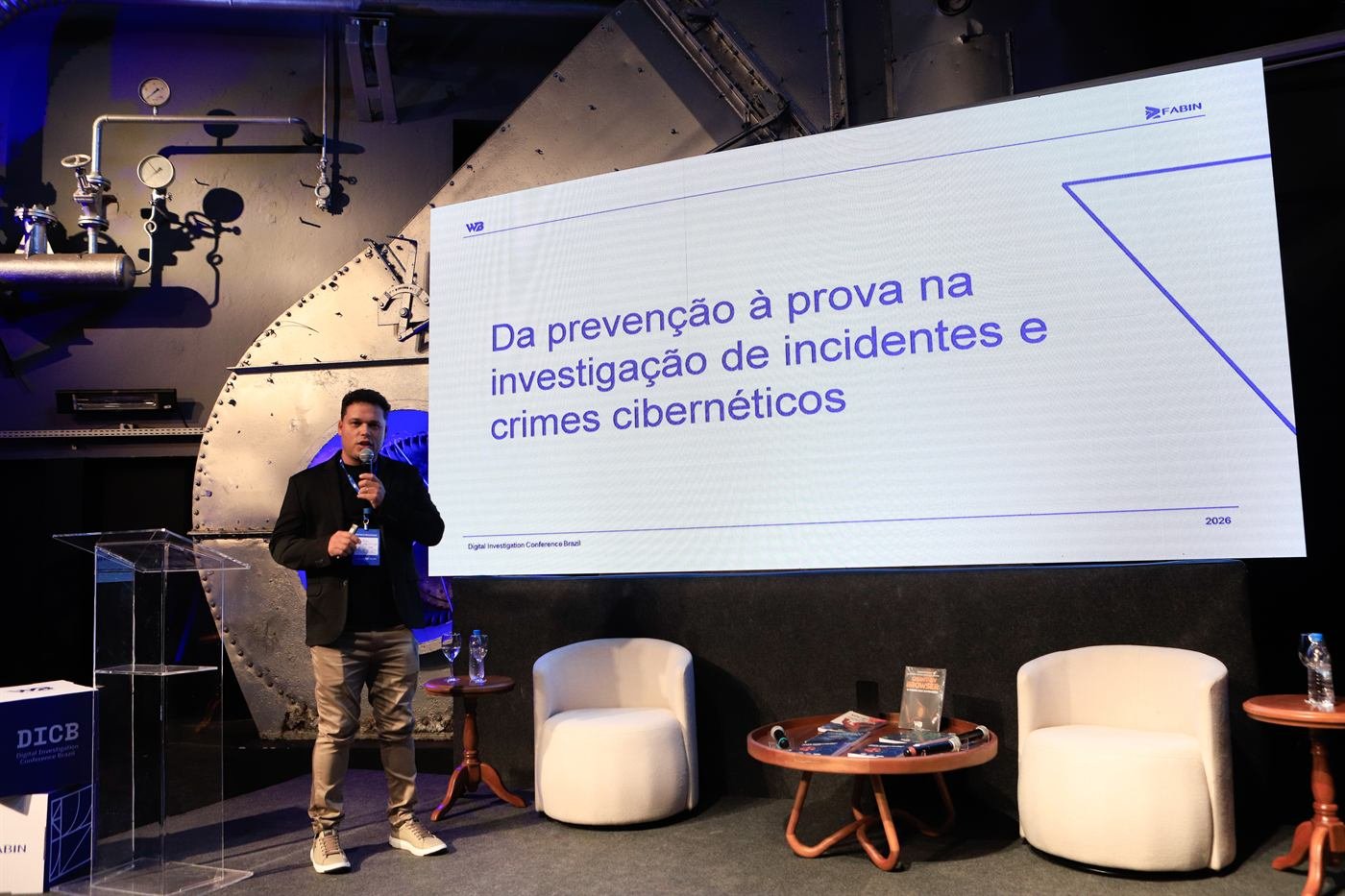 Elias Edenis no palco ao lado de um telão com o título “Da prevenção à prova na investigação de incidentes e crimes cibernéticos”.